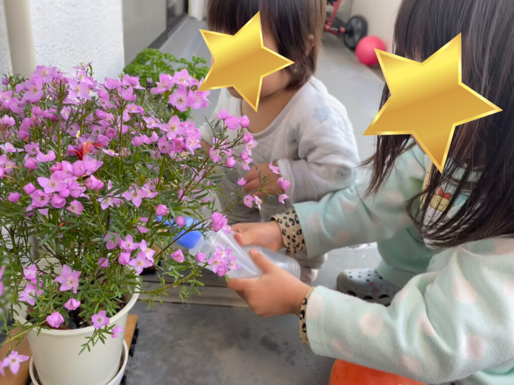 ベランダで、お花に水やりをする子どもたち